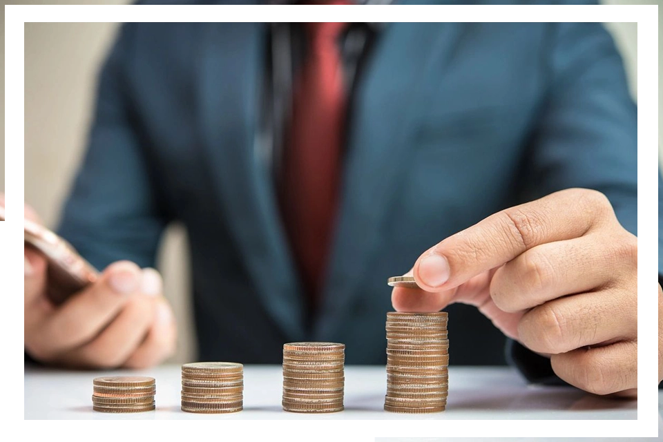 A man in a suit and tie stacking coins.