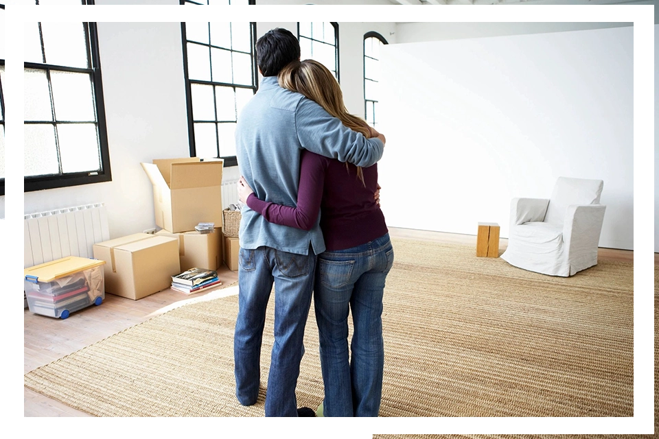 A man and woman hugging in the living room.