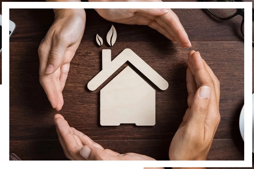 A group of people holding hands around a house.