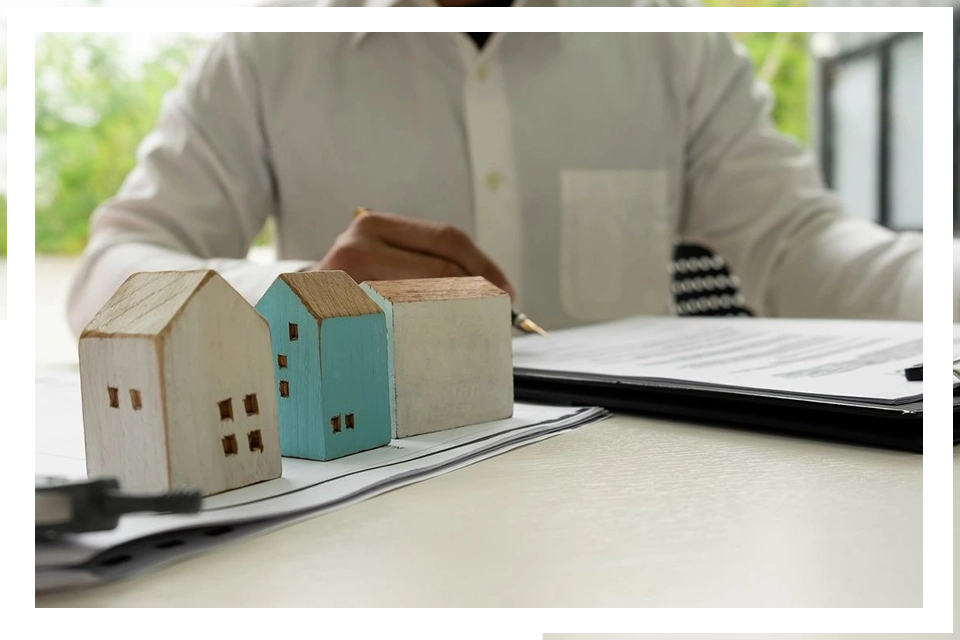 A man sitting at a table with some houses on top of it.